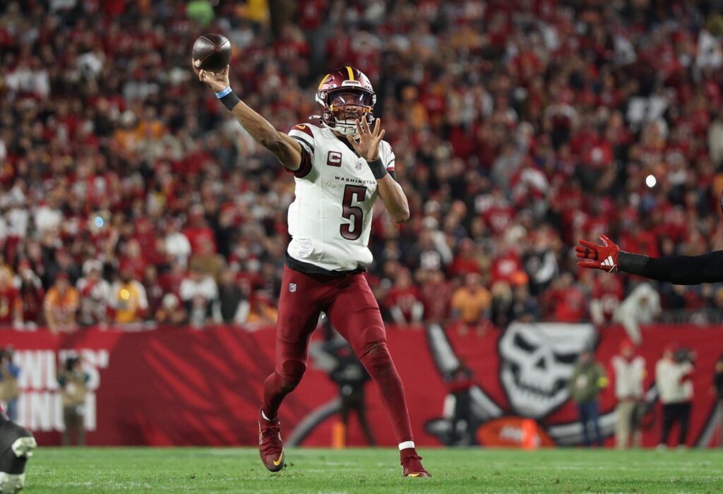 Jan 12, 2025; Tampa, Florida, USA; Washington Commanders quarterback Jayden Daniels (5) throws during the second quarter of a NFC wild card playoff against the Tampa Bay Buccaneers at Raymond James Stadium. Mandatory Credit: Nathan Ray Seebeck-Imagn Images
